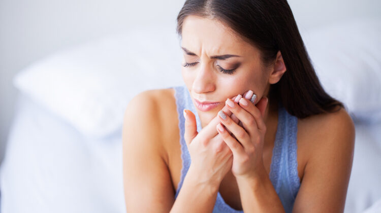 Woman Feeling Tooth Pain and Holding Chin