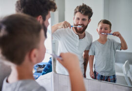 Shot of a father and his little son brushing their teeth together in the bathroom at home.