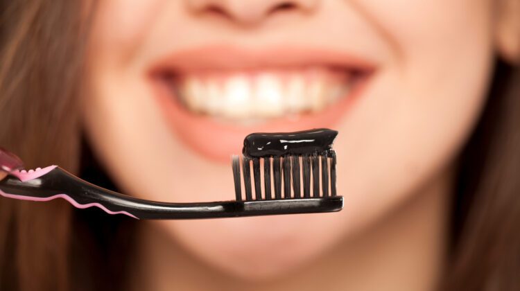 A Woman Holding a Black Color Bristles Brush in Hand